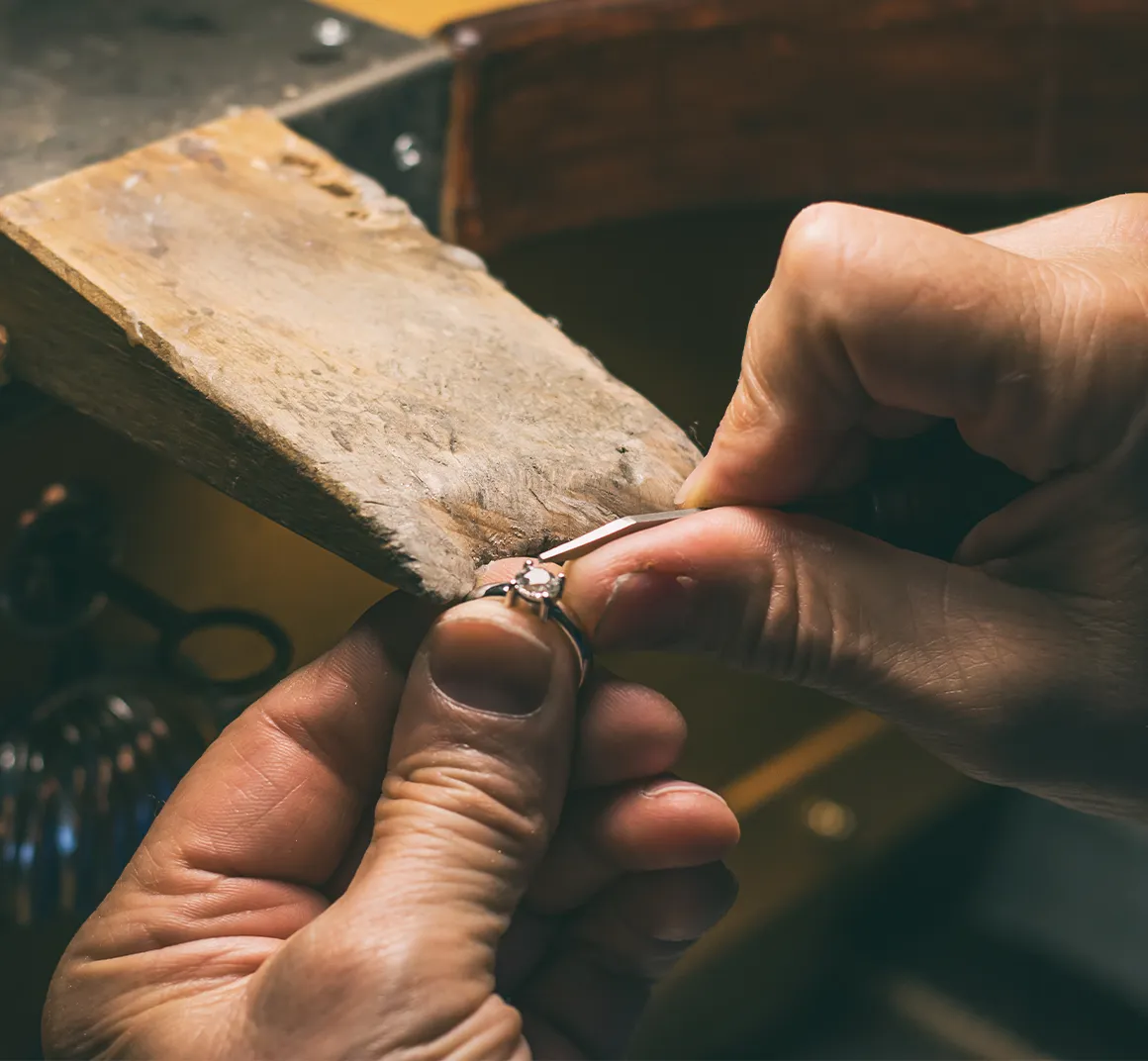 A goldsmith finishing a diamond ring at the bench